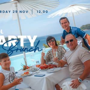 Smiling family celebrating with seafood and champagne at a luxurious pool party brunch, November 2025.